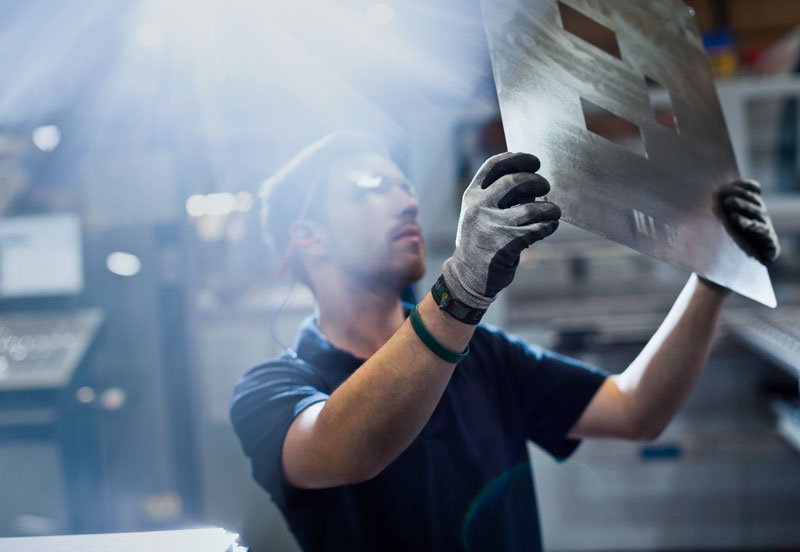 steelworker examining punch out cut work